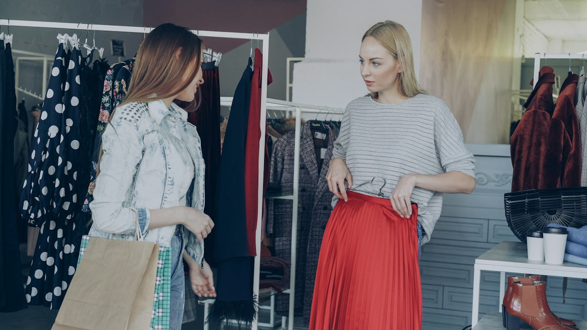 two women discussing fashion while shopping for buying women's dresses and men's jeans online