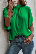 Model wearing a dark green tie back slit blouse with half sleeves and slightly stretchy material.