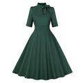 1950s retro swing dress for women in dark green with short sleeves and tie neck detail.