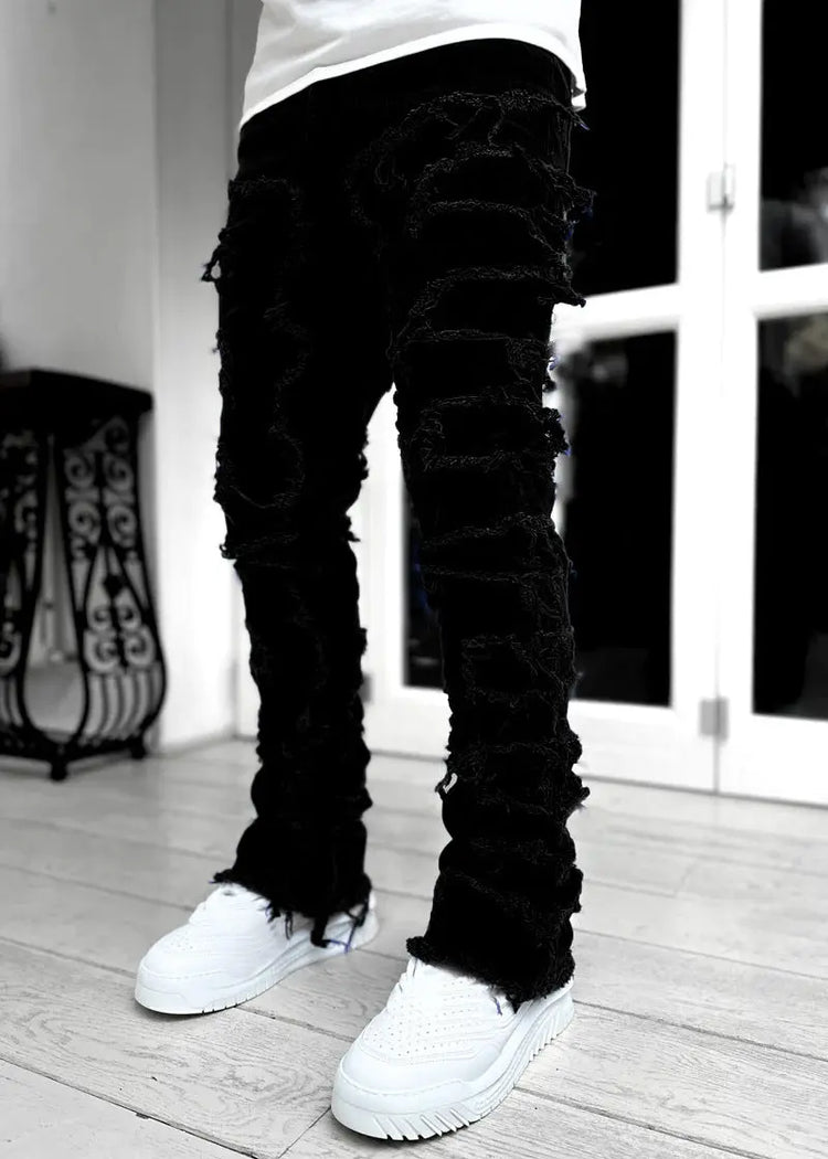 Pink ripped jeans with fringes, patched details, and a long, tight-fit stacked design for men&