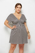Printed deep v-neck dress with elastic waist in checkered pattern, featuring a flattering fit and stylish design.