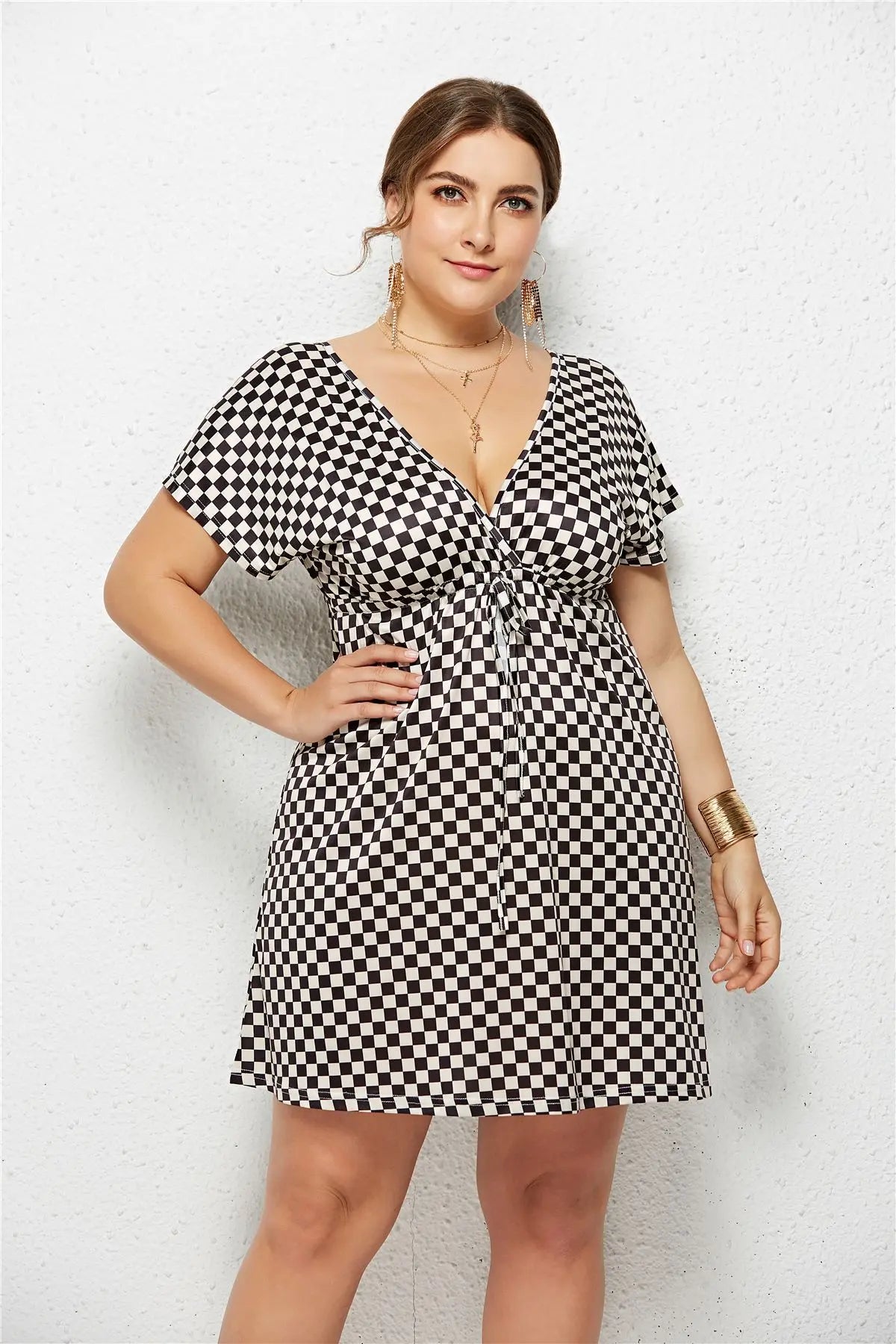 Printed deep v-neck dress with elastic waist in checkered pattern, featuring a flattering fit and stylish design.