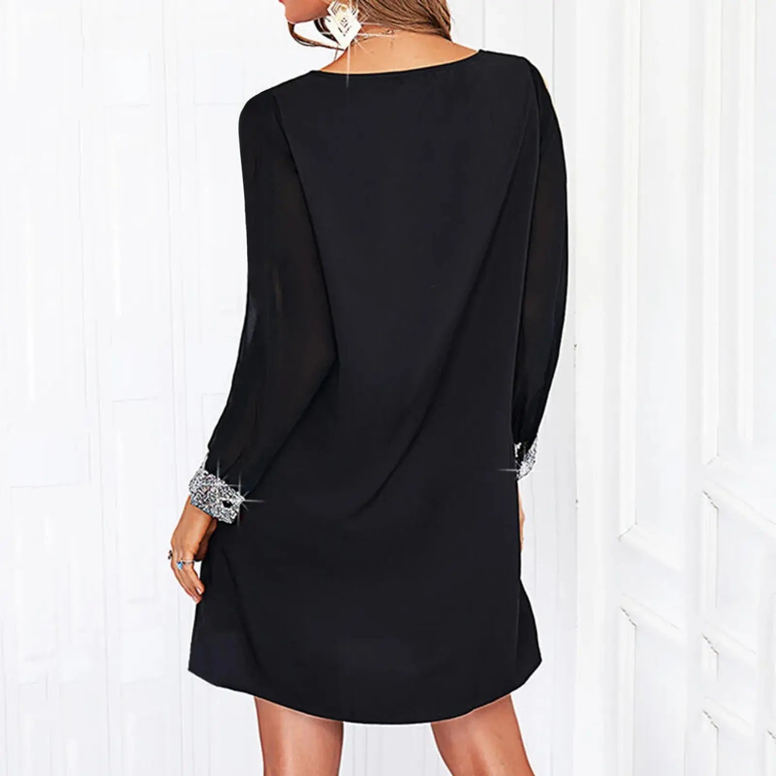 Elegant black mini dress for women by SHOPEZRA L.L.C., featuring shiny mesh stitching, long sleeves, V-neck, and solid color design.