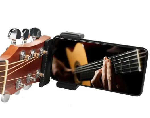 Close-up of a guitar phone clip stand holding a smartphone that displays a guitarist's fingers on the strings.