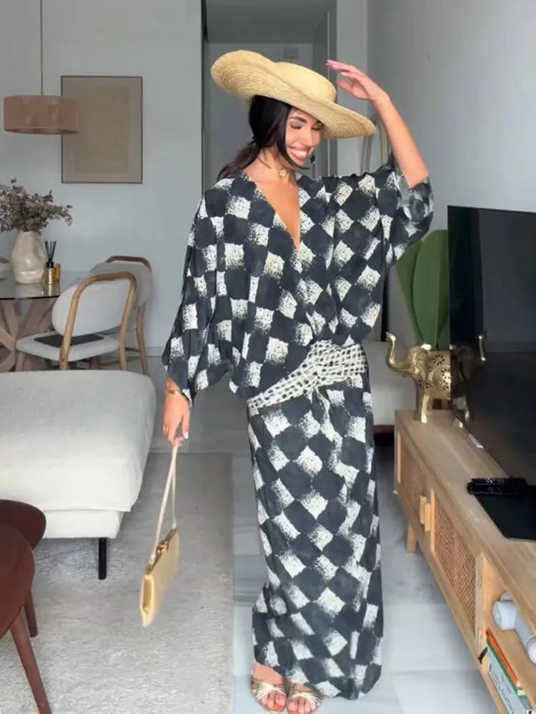 Elegant black plaid women's dress with V-neck, batwing sleeves, and waist cinching, perfect for spring and summer casual wear.
