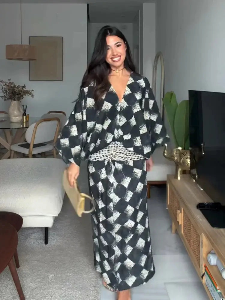 Elegant black plaid women's dress with V-neck, batwing sleeves, and waist cinching, perfect for spring and summer casual wear.