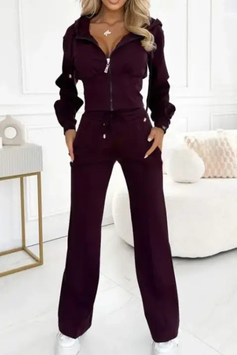 Stylish woman wearing a hooded jacket and pants set in burgundy for fall and winter comfort.