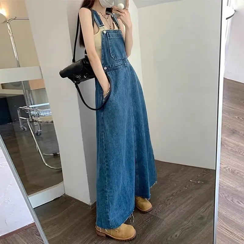 Blue denim suspender dress for women, loose fit, long style, suitable for tall women, from SHOPEZRA L.L.C., autumn 2026 collection.