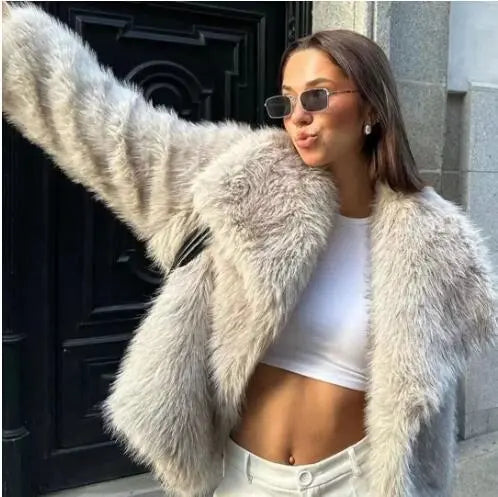 Stylish model wearing a womens plush winter coat, showcasing elegance and warmth against a city backdrop.