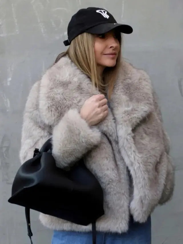 Stylish woman wearing a womens plush winter coat, accessorized with a black handbag and cap.