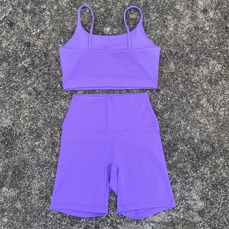 Purple women's tight yoga cycling shorts and U-shaped strap sports bra set, with outerwear for gym and yoga activities.