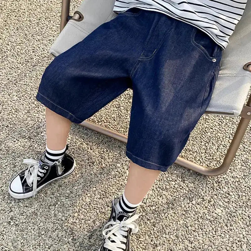 Boy wearing casual denim shorts from SHOPEZRA L.L.C., knee-length summer fashion trousers for kids aged 3-12 years.