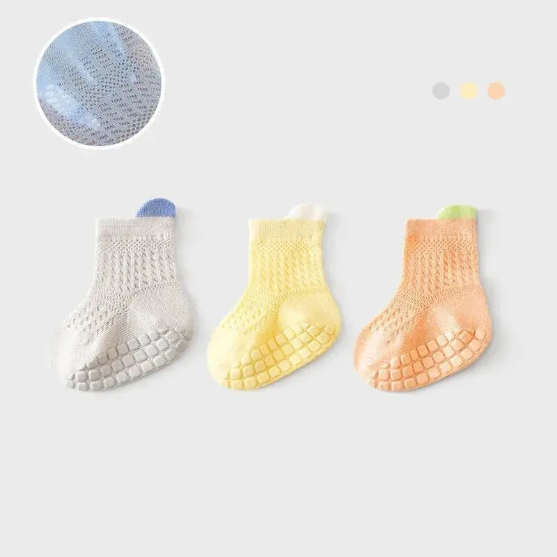 Set of three pairs of breathable, non-slip baby girl cotton socks with colorful designs and mesh accents for infants and kids.