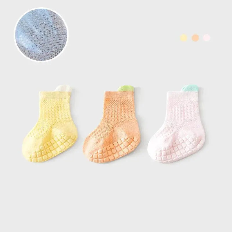 Set of three pairs of SHOPEZRA L.L.C. baby girl cotton socks with colorful non-slip grips, breathable and mesh for infants and kids.