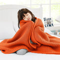 Child resting with Guohaoi knitted weighted blanket for hot sleepers in vibrant orange color, 50"x60".