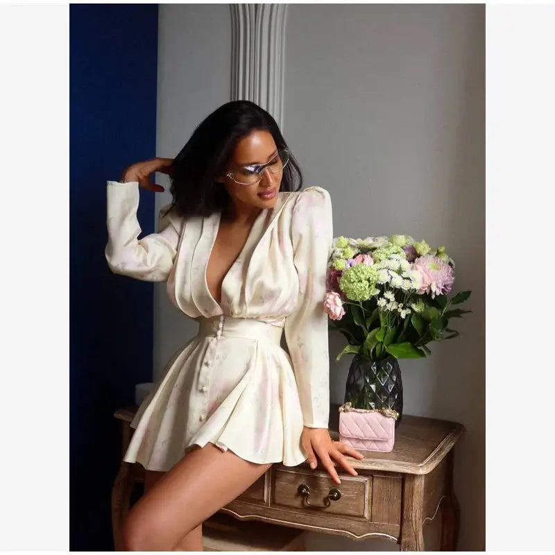 Elegant floral printed waist-cinched mini dress for women with pleated design, deep V-neck, long sleeves, and button-front.