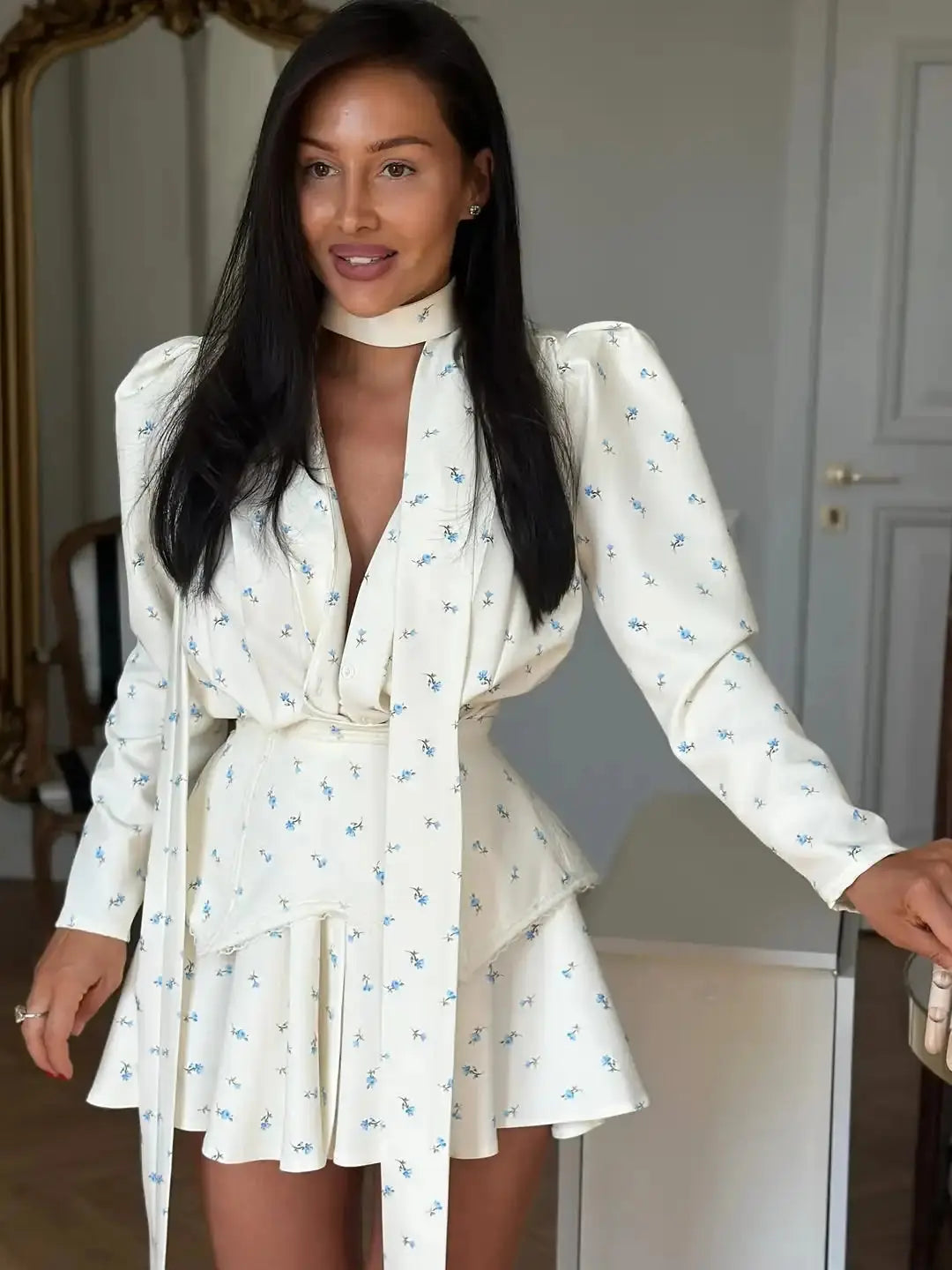 Elegant floral print mini dress for women with waist cinch, deep V-neck, long sleeves, pleats, and button front for fashion parties.