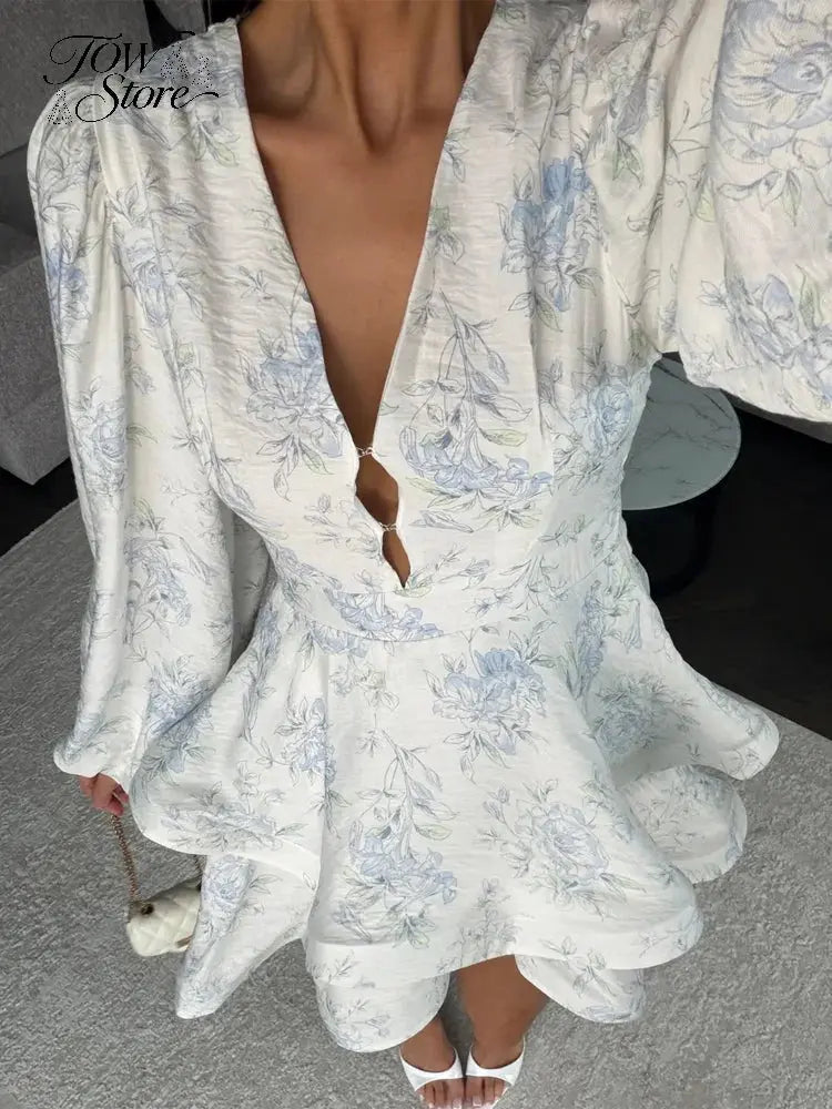 Elegant floral printed mini dress for women with waist cinch, pleated design, deep V-neck, long sleeves, and button-front style.