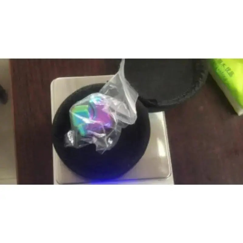 Colorful fidget spinner stress relief toy inside packaging on top of a black display base.