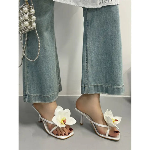 Elegant white high-heeled sandals for women with thong design, part of SHOPEZRA L.L.C.'s 2025 summer fashion collection.