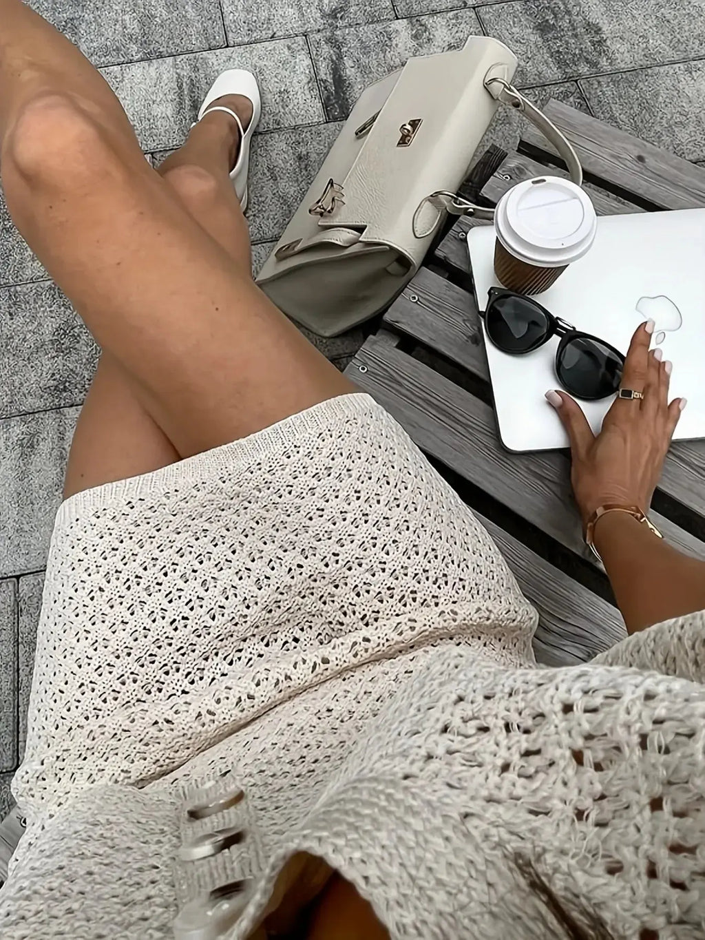 Openwork sweater set for women featuring a button-up top and skirt, paired with accessories and coffee.
