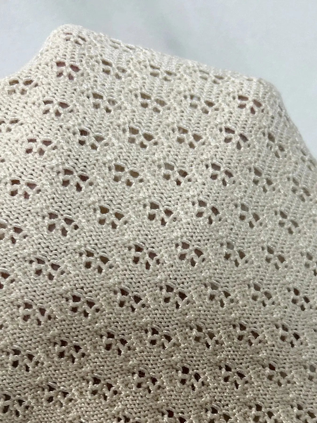 Detail of openwork texture on an openwork sweater set for women, highlighting its unique design and pattern.
