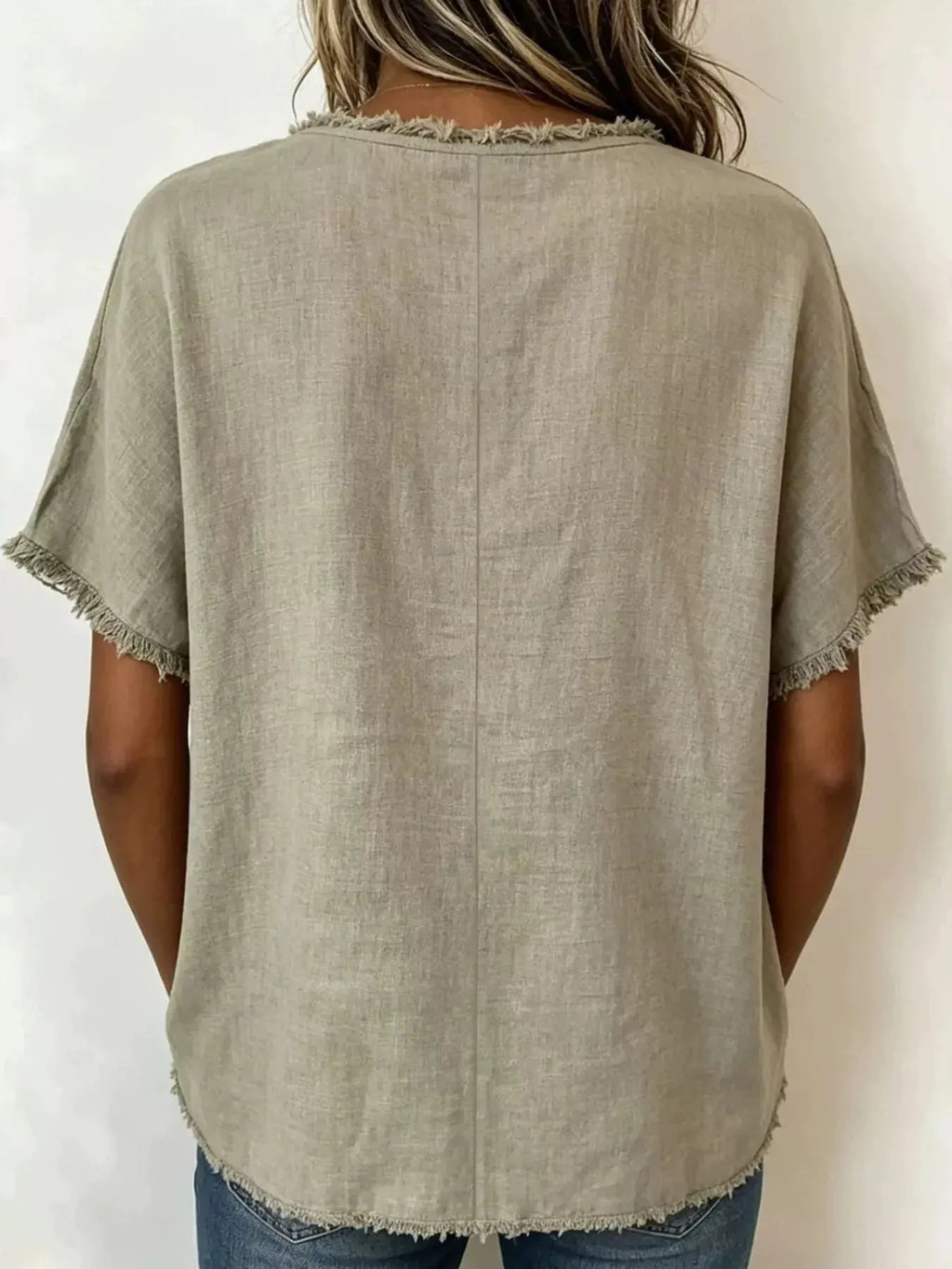 Plus size frayed hem top in a relaxed fit with short sleeves and unique frayed hemline, shown from the back.