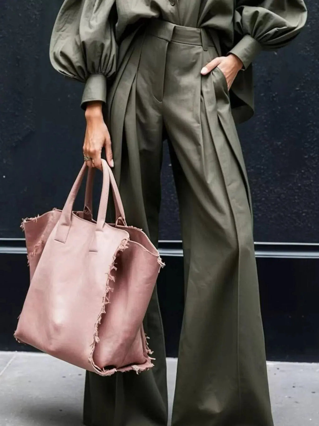 Model showcases a fashionable lantern sleeve shirt and wide leg pants set paired with a pink tote bag.