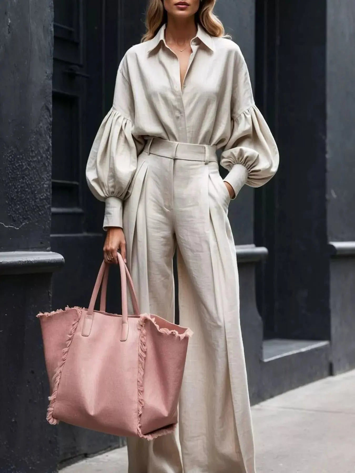 Stylish model wearing a lantern sleeve shirt and wide leg pants set in khaki with a pink tote bag.